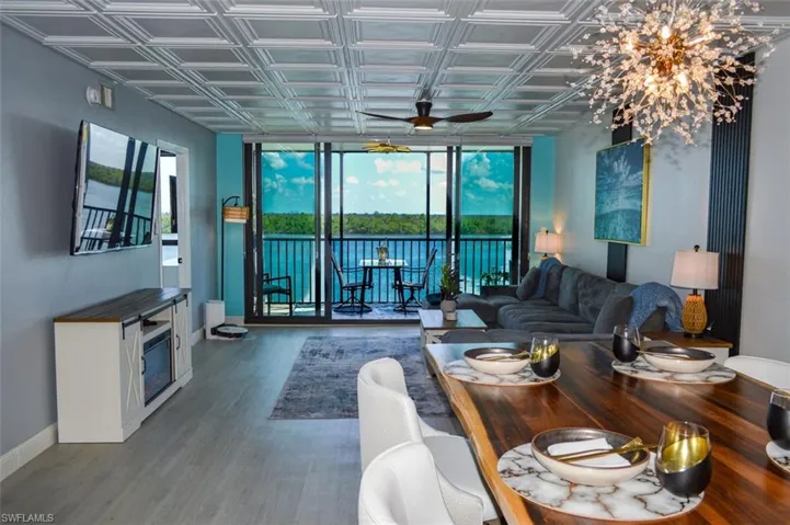 VIEW FROM DINING AREA SHOWING LANAI AND ENTRANCE (TO LEFT) FOR OWNER'S SUITE.  65" WALL-MOUNTED FLAT SCREEN TV.