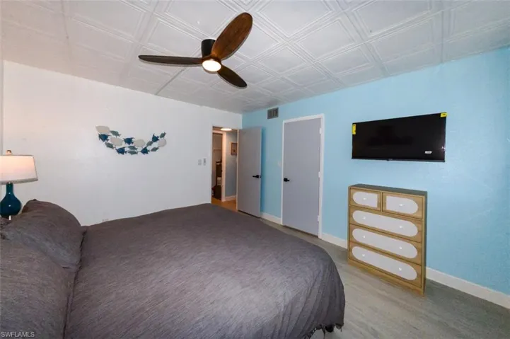 GUEST BEDROOM.  MIDDLE DOOR IS TO WALK-IN CLOSET.  WALL-MOUNTED FLAT SCREEN TV.