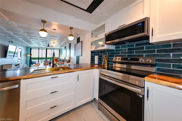 ACACIA BUTCHER BLOCK COUNTERTOPS.  SAMSUNG APPLIANCES.  FULL HEIGHT TILED BACKSPLASH.  LARGE PULL-OUT SINGLE DRAWER UNDER SINK.