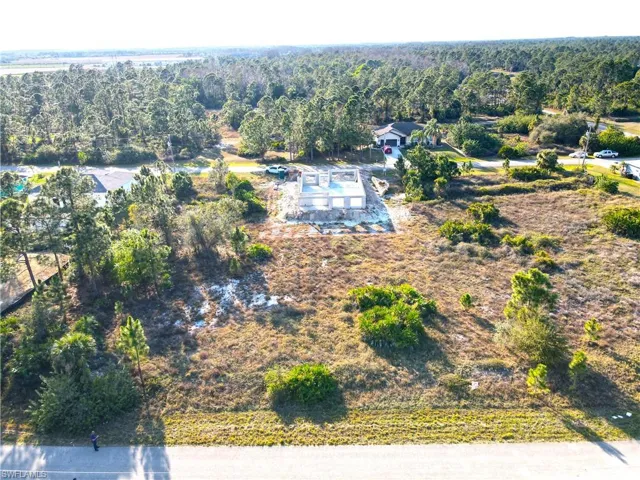 Birds eye view of property with a wooded view