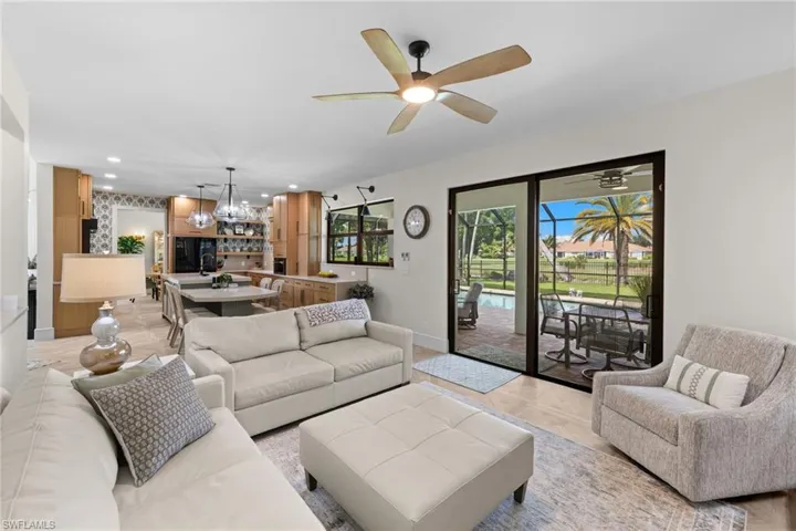 Living area featuring large format tile flooring, a ceiling fan with integrated lighting, and expansive sliding glass doors