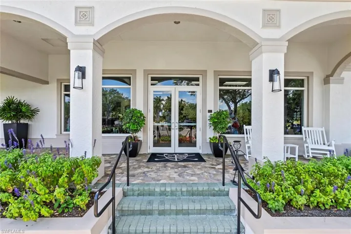 The property features an inviting entrance with arched columns, glass panel doors, and decorative wall sconces