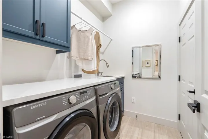 This utility room features built-in cabinetry, a countertop, and a basin with a faucet