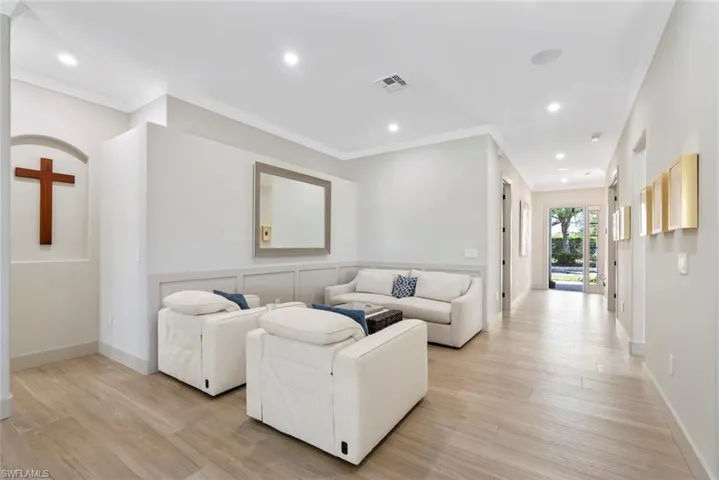 Inviting interior space featuring light-colored flooring, recessed lighting, and crown molding