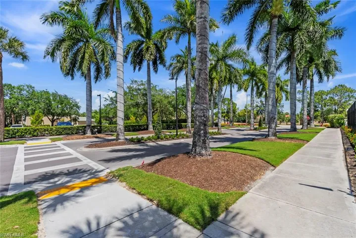The community features mature palm trees and well-maintained landscaping, with sidewalks and paved roadways
