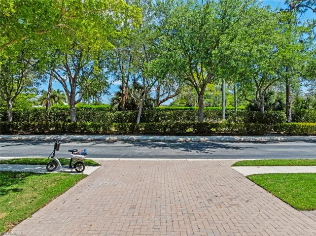 The property features a brick paver driveway and a well-maintained lawn