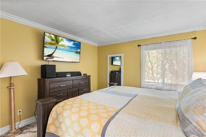Bedroom with crown molding and baseboards
