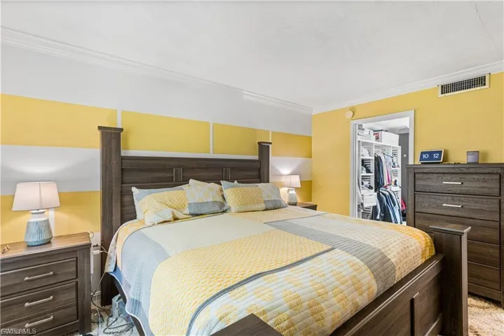 Bedroom featuring ornamental molding and a walk in closet