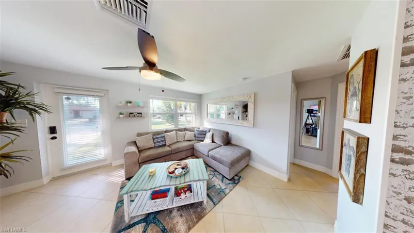Living area with light tile patterned floors and a ceiling fan