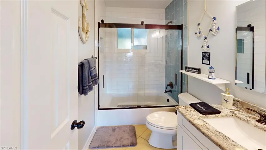 Bathroom with vanity, combined bath / shower with glass door, and light tile patterned floors