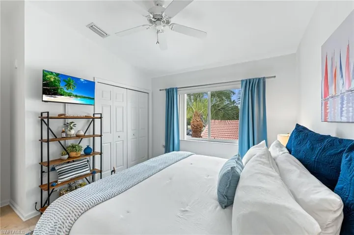 Bedroom featuring vaulted ceiling, a ceiling fan, a closet, and wood finished floors