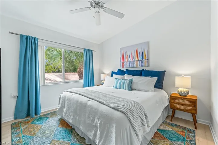 Bedroom featuring lofted ceiling, light wood-style flooring, and ceiling fan
