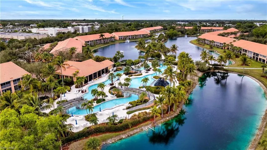 Drone / aerial view of a nearby body of water and a pool area