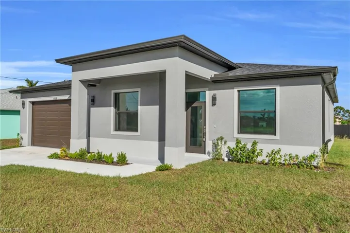 View of front facade featuring stucco siding, a front lawn, an attached garage, and covered porch