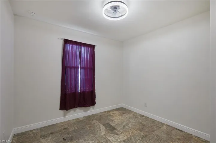 Empty room featuring baseboards and stone finish flooring
