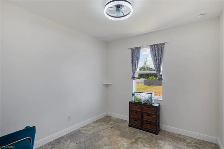 Unfurnished room with baseboards and stone finish floor