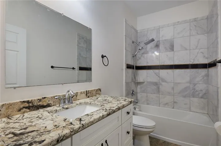Full bathroom featuring toilet, bathing tub / shower combination, and vanity