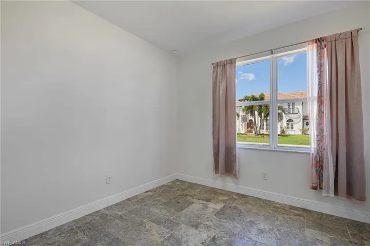 Unfurnished room featuring baseboards and stone finish floor