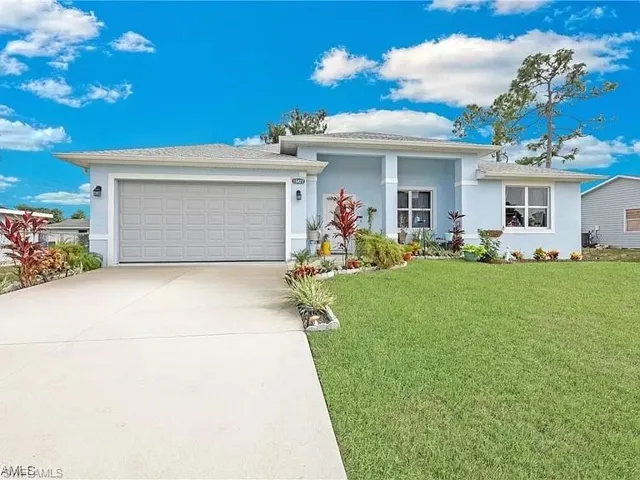 View of front of home featuring a front yard, concrete driveway, a garage, and stucco siding