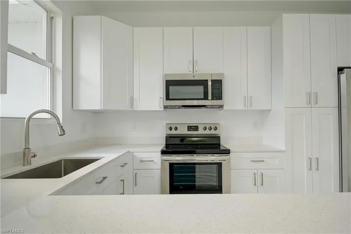 Kitchen featuring appliances with stainless steel finishes and white cabinetry