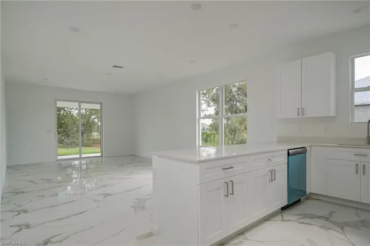 Kitchen featuring white cabinetry, kitchen peninsula, and sink