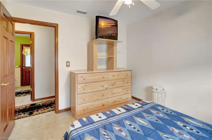 Bedroom with ceiling fan and light tile patterned floors