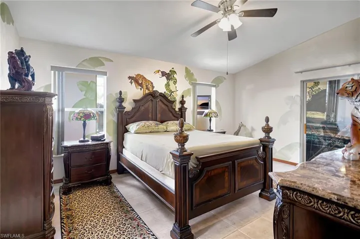 Bedroom featuring ceiling fan, light tile patterned flooring, and multiple windows