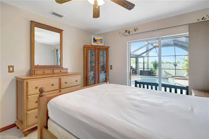 Carpeted bedroom featuring ceiling fan and access to outside