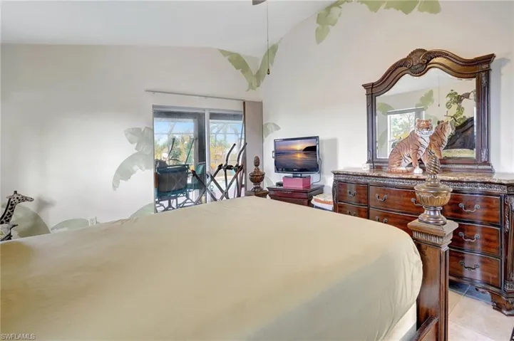 Bedroom with light tile patterned floors, access to exterior, and lofted ceiling