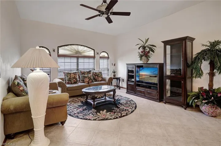 Living room with ceiling fan and light tile patterned flooring