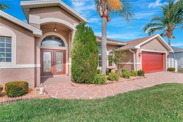 Entrance to property with a lawn, french doors, and a garage