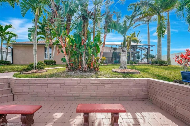 View of property's community featuring a patio area and a lawn