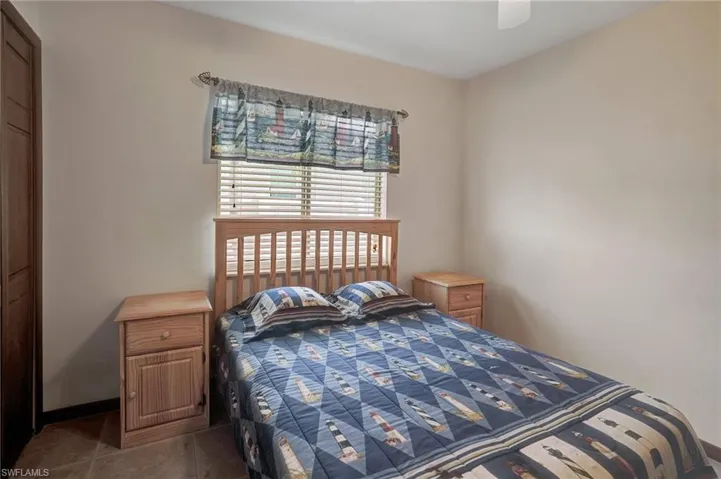 Bedroom with ceiling fan and dark tile patterned flooring