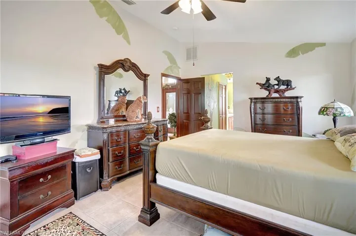 Tiled bedroom featuring ceiling fan and lofted ceiling