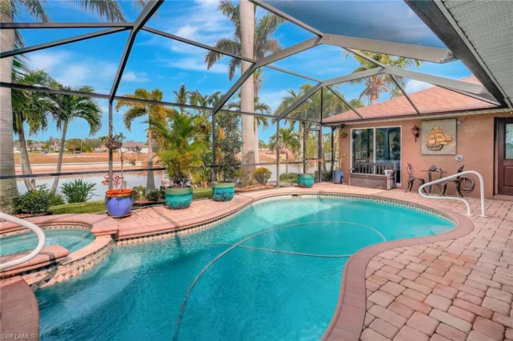 View of swimming pool with a lanai, a patio area, and an in ground hot tub