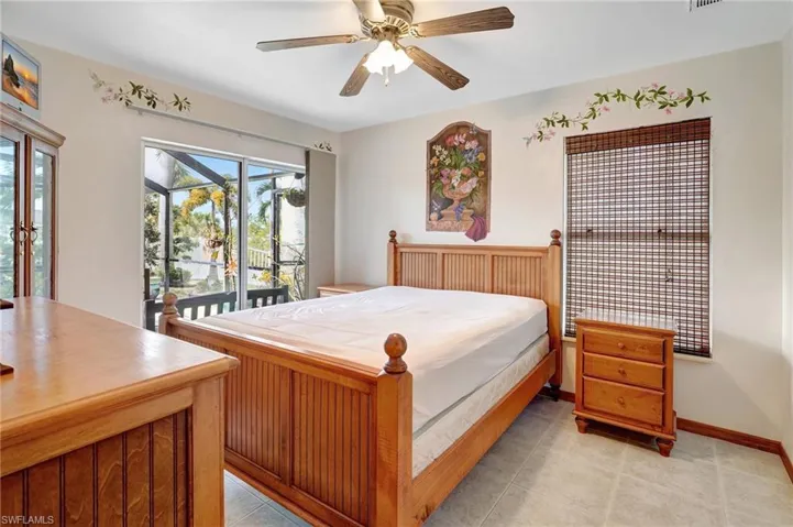 Bedroom with ceiling fan, access to exterior, and light tile patterned flooring