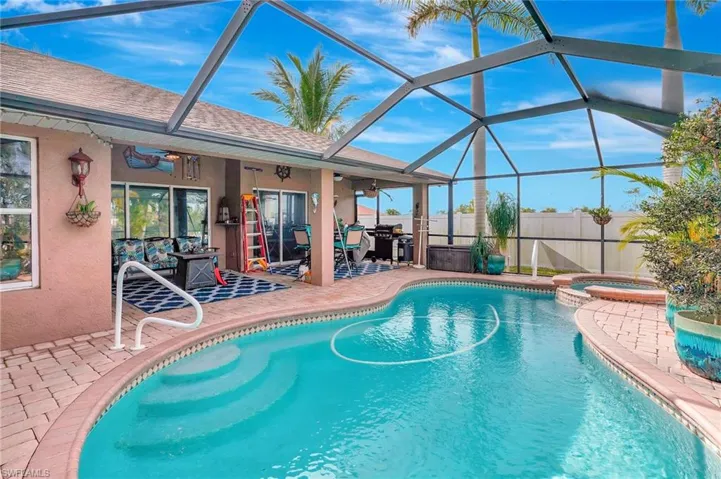 View of pool featuring an in ground hot tub, glass enclosure, ceiling fan, and a patio