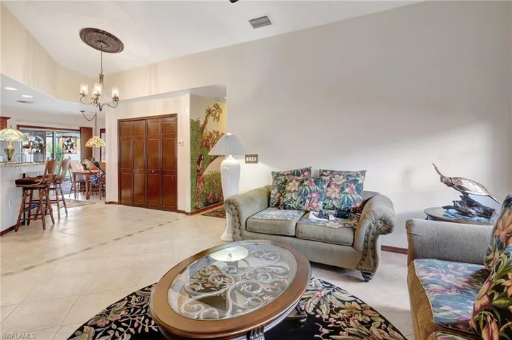 Living room featuring light tile patterned floors and a chandelier
