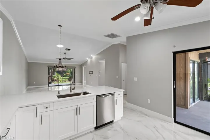 Kitchen featuring dishwasher, ornamental molding, a ceiling fan, a peninsula, and plenty of natural light