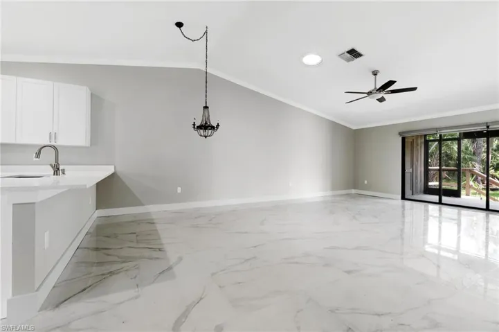 Unfurnished living room featuring light marble finish flooring, ceiling fan, crown molding, lofted ceiling, and recessed lighting