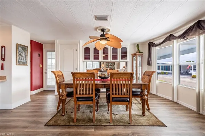 Dining area with wood finished floors, ceiling fan, baseboards, and visible vents