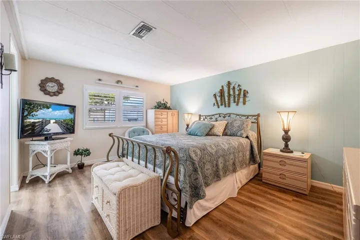 Bedroom with visible vents, baseboards, and wood finished floors