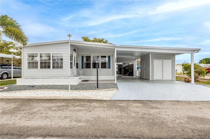 Manufactured / mobile home with concrete driveway and a carport