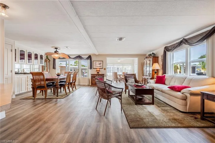 Living room featuring visible vents, ceiling fan, beam ceiling, and wood finished floors