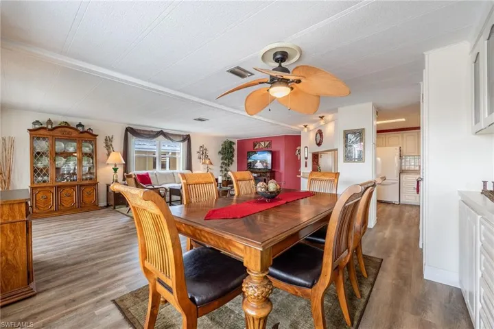 Dining space with wood finished floors, a ceiling fan, and visible vents
