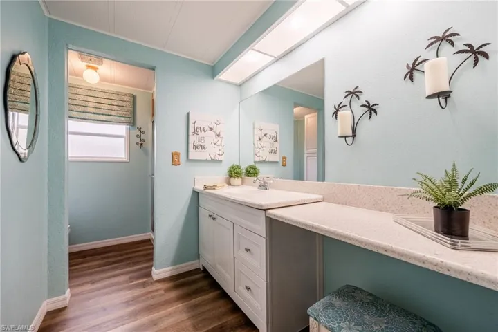 Bathroom with baseboards, vanity, and wood finished floors