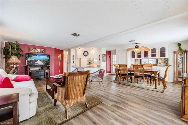 Living room featuring visible vents, baseboards, light wood finished floors, and a ceiling fan