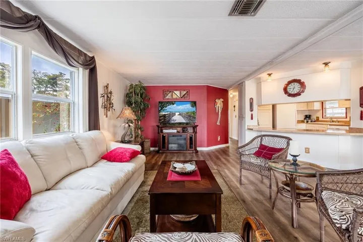 Living room featuring visible vents, baseboards, wood finished floors, and a fireplace
