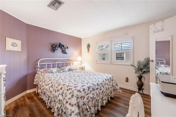 Bedroom featuring wood finished floors, baseboards, and visible vents