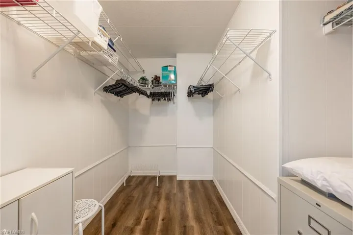 Walk in closet featuring dark wood-type flooring